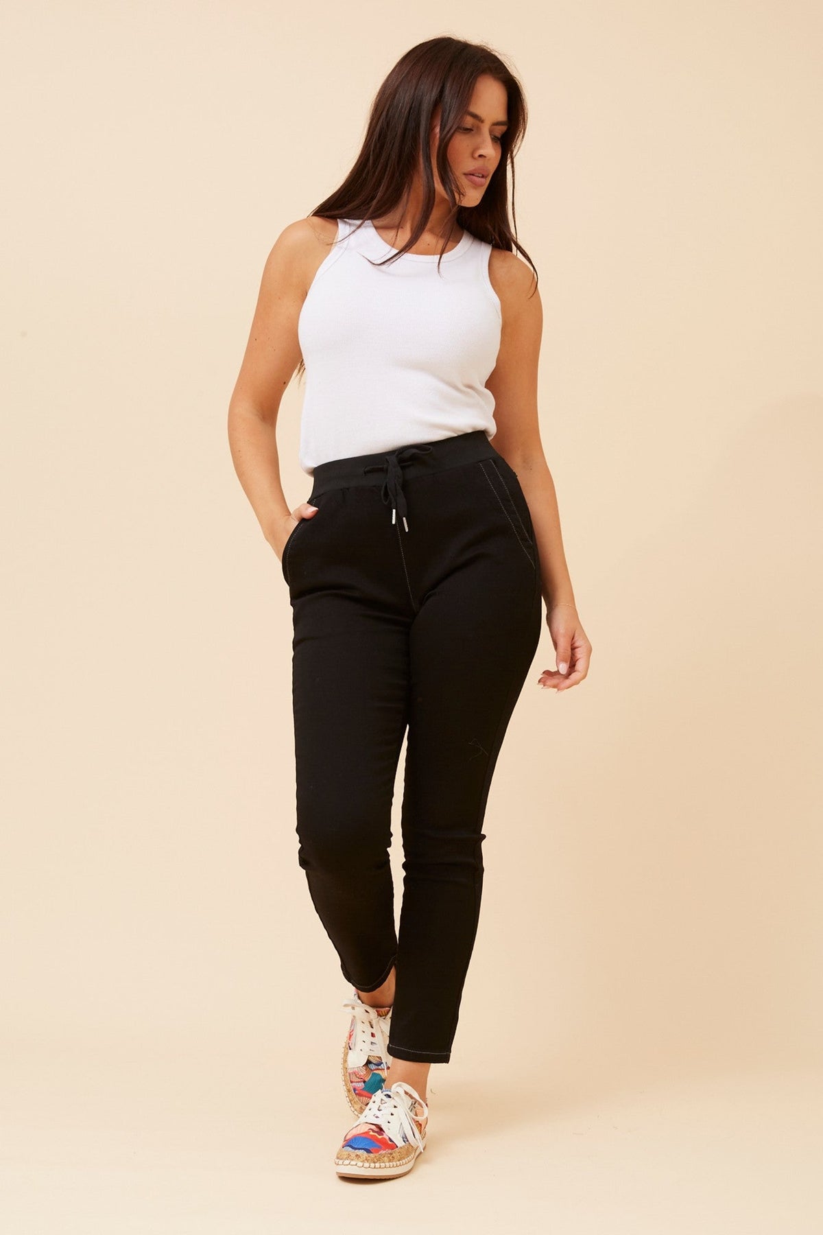 Image of a model wearing Pants. Product name - JANJA SOLID JOGGER PANTS in Black colour by brand - Caroline Morgan Australia
