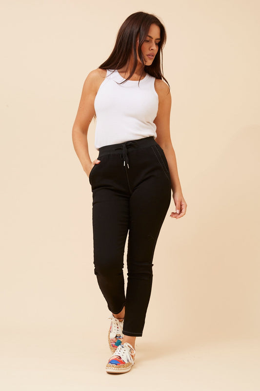 Image of a model wearing Pants. Product name - JANJA SOLID JOGGER PANTS in Black colour by brand - Caroline Morgan Australia