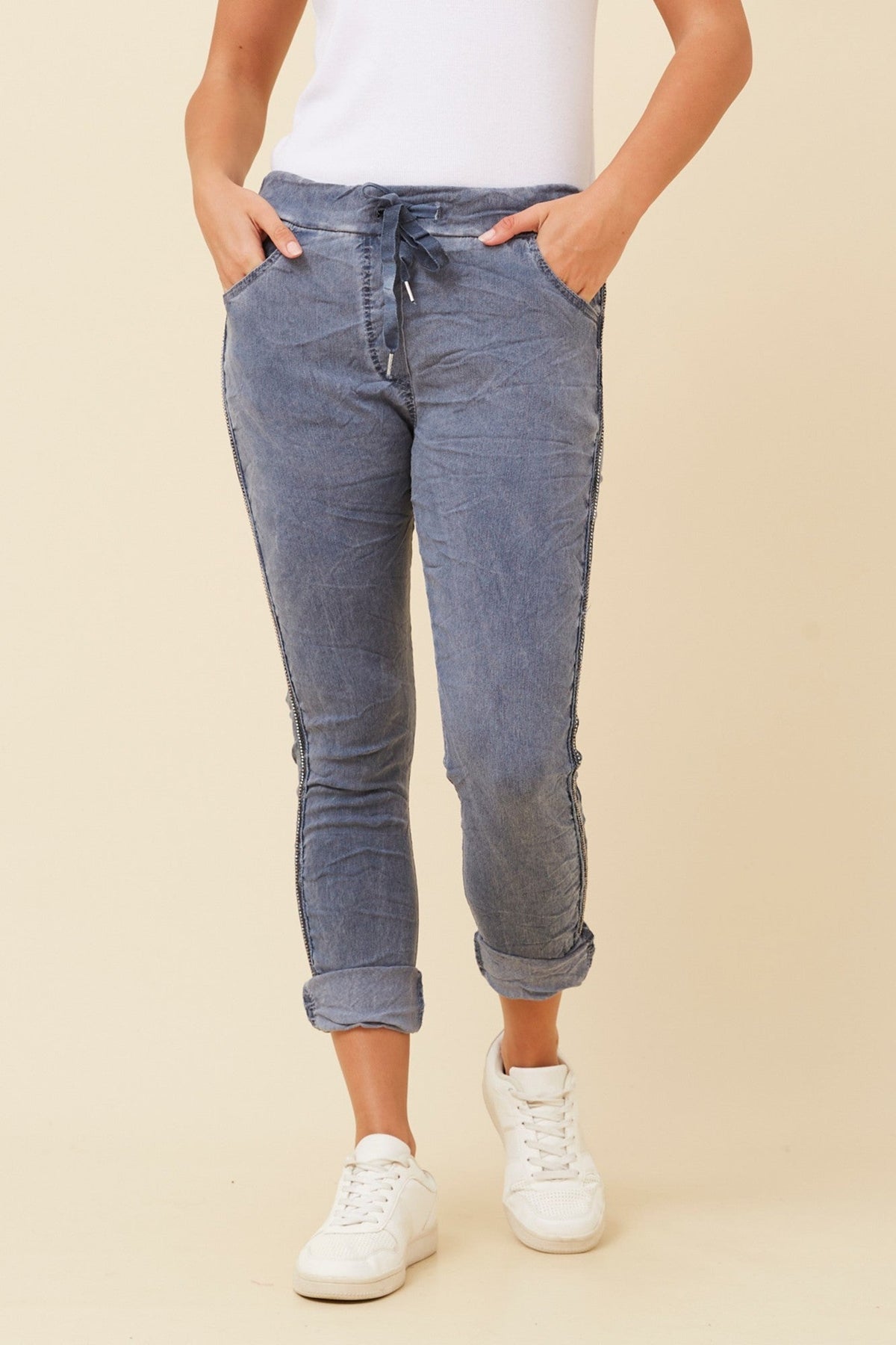 Image of a model wearing Pants. Product name - ZANJA DIAMANTE DETAIL JOGGER PANTS in Dark Denim colour by brand - BOTTEGA MODA
