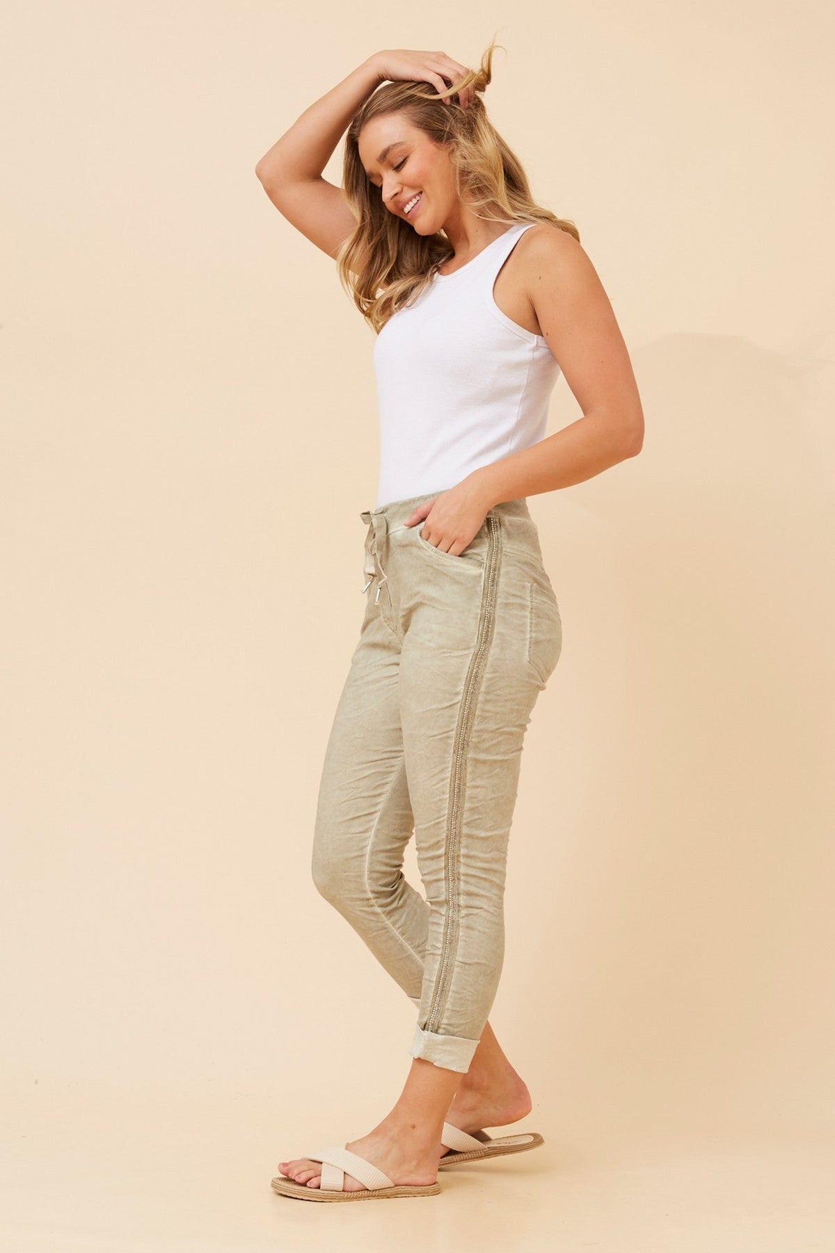Image of a model wearing Pants. Product name - ZANJA DIAMANTE DETAIL JOGGER PANTS in Light Khaki colour by brand - BOTTEGA MODA