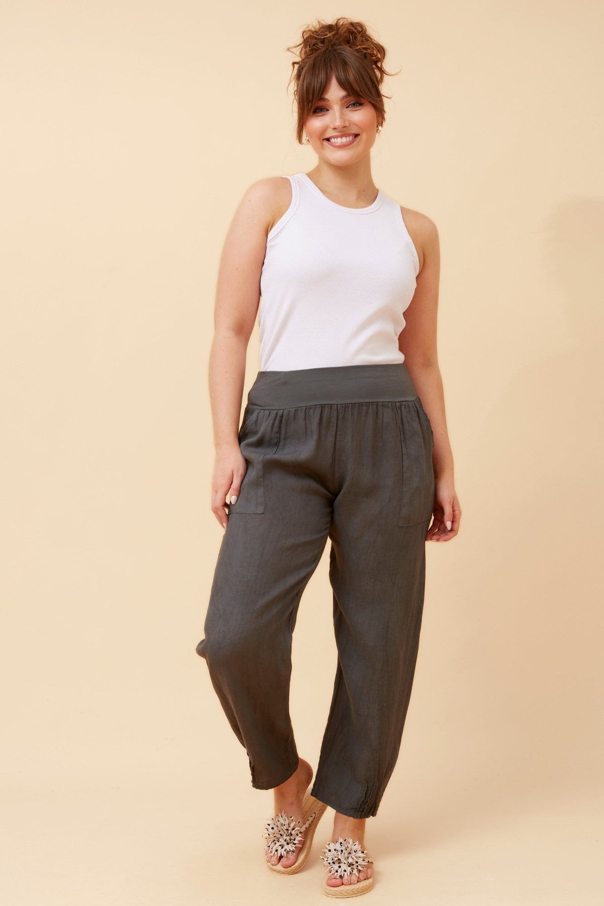 Image of a model wearing Pants. Product name - FINN SOLID LINEN PANTS in Charcoal colour by brand - BOTTEGA MODA