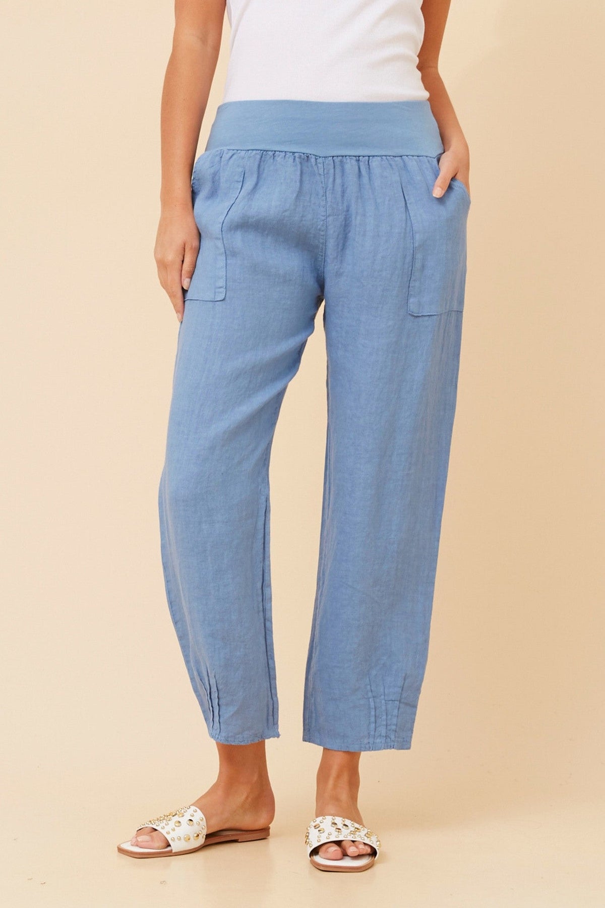 Image of a model wearing Pants. Product name - FINN SOLID LINEN PANTS in Denim colour by brand - BOTTEGA MODA
