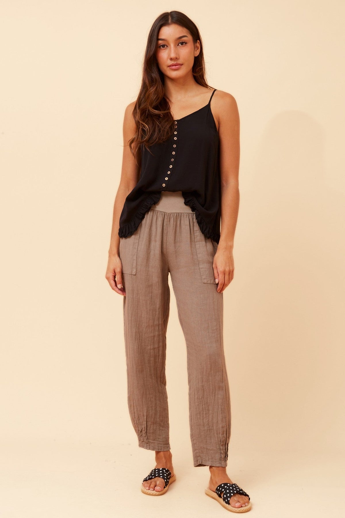 Image of a model wearing Pants. Product name - FINN SOLID LINEN PANTS in Fango colour by brand - BOTTEGA MODA