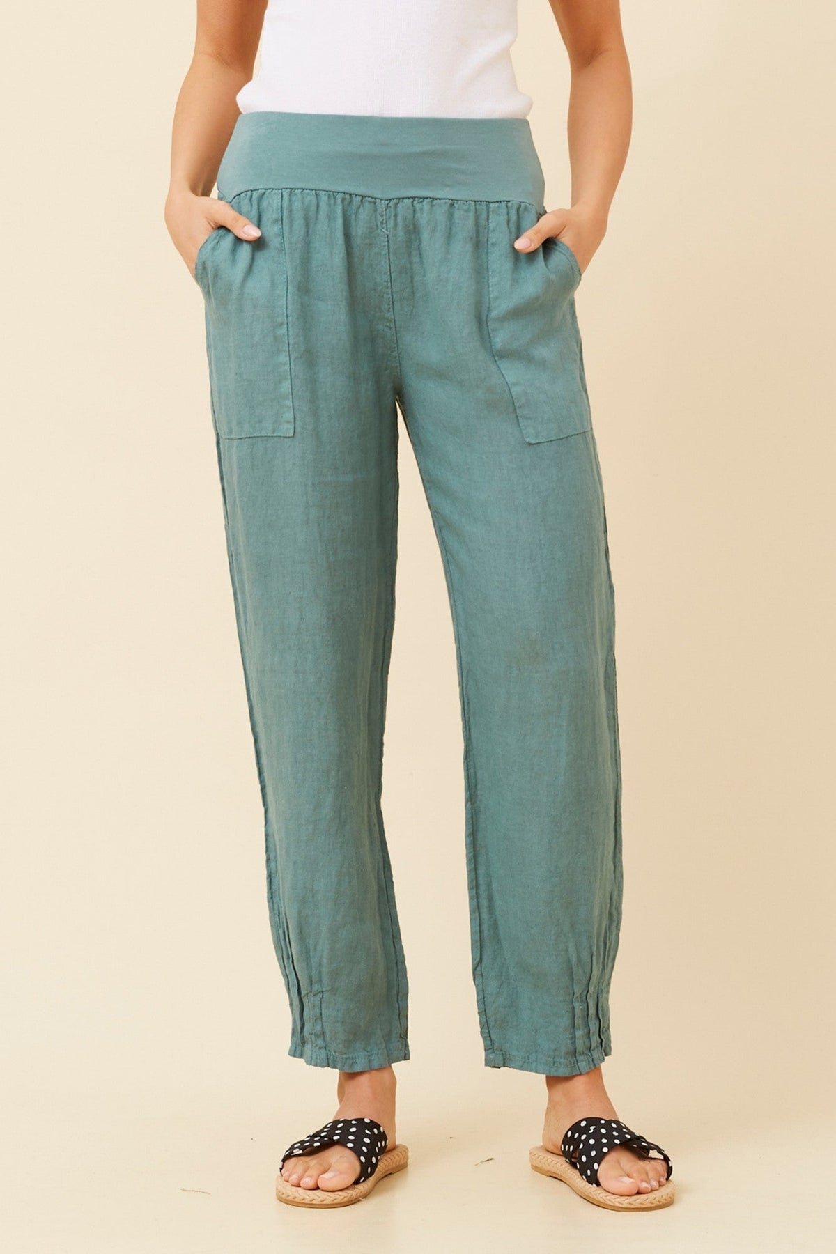 Image of a model wearing Pants. Product name - FINN SOLID LINEN PANTS in Lago colour by brand - BOTTEGA MODA