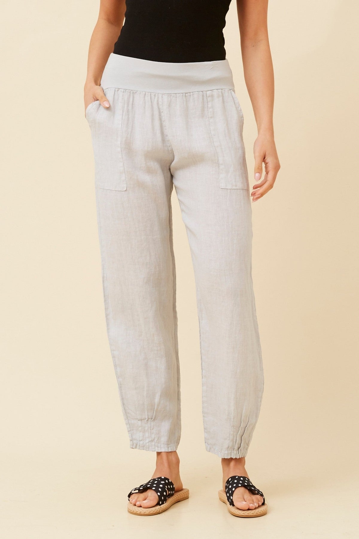 Image of a model wearing Pants. Product name - FINN SOLID LINEN PANTS in Perla colour by brand - BOTTEGA MODA