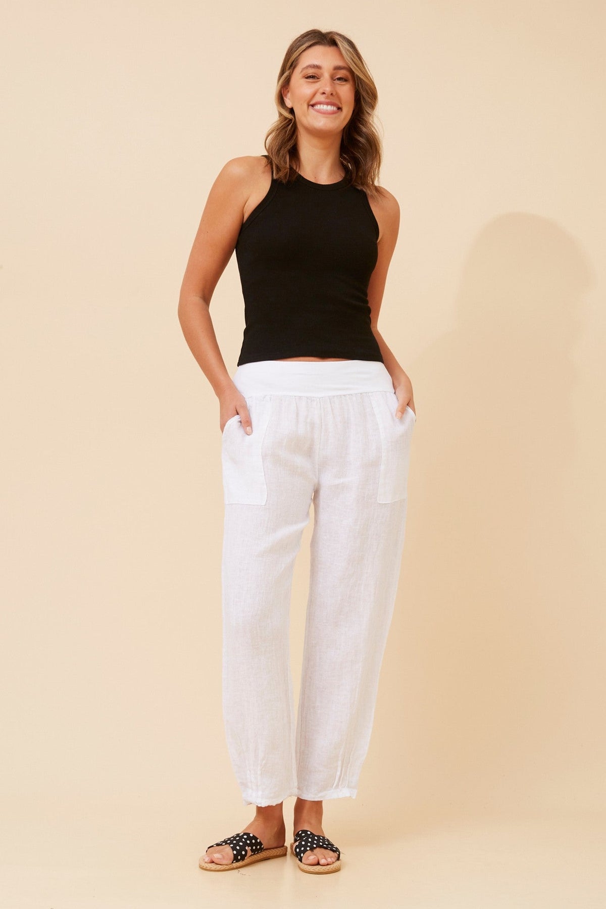 Image of a model wearing Pants. Product name - FINN SOLID LINEN PANTS in White colour by brand - BOTTEGA MODA