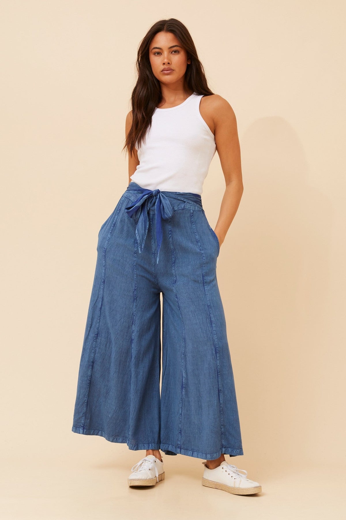 Image of a model wearing Pants. Product name - ANETTA FLARE LEG PANTS in Dark Denim colour by brand - Caroline Morgan Australia