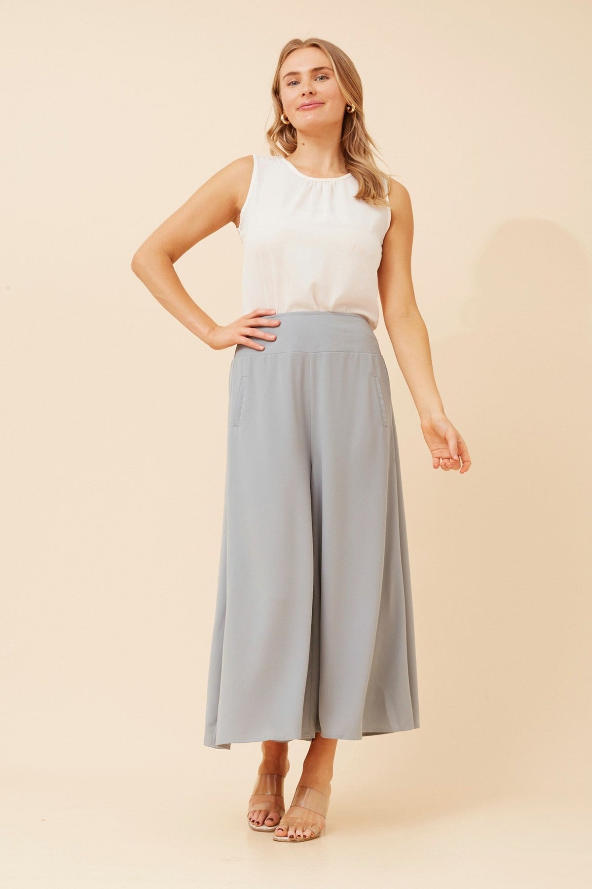 Image of a model wearing Pants. Product name - AVARA WIDE LEG PANTS in Sage colour by brand - Caroline Morgan Australia