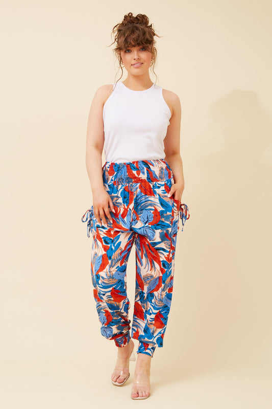 Image of a model wearing Pants. Product name - LEAF PRINT HAREM PANTS in Multi Blue colour by brand - Caroline Morgan Australia