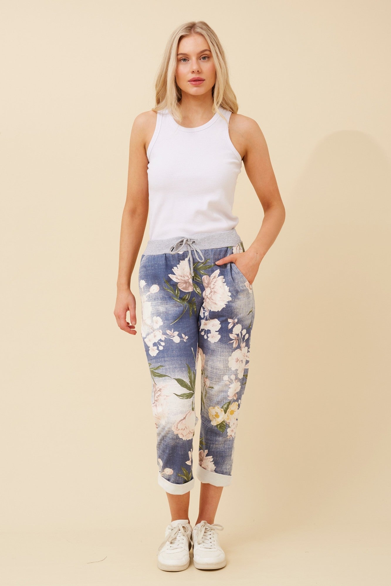 Image of a model wearing Pants. Product name - GINNA FLORAL JOGGER PANTS in Denim colour by brand - BOTTEGA MODA