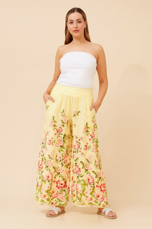 Image of a model wearing Pants. Product name - LEONORA FLORAL WIDE LEG LINEN PANTS in Butter colour by brand - BOTTEGA MODA