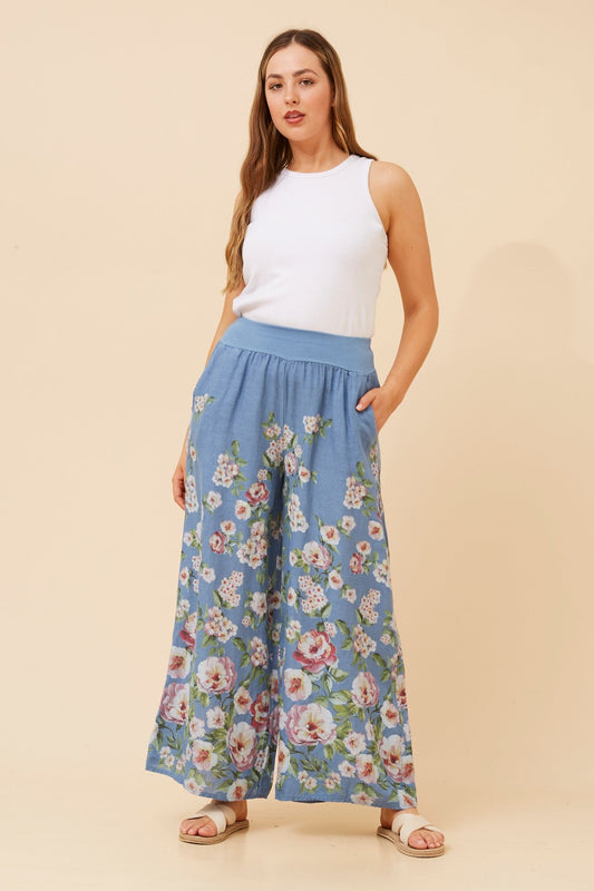 Image of a model wearing Pants. Product name - LEONORA FLORAL WIDE LEG LINEN PANTS in Denim colour by brand - BOTTEGA MODA