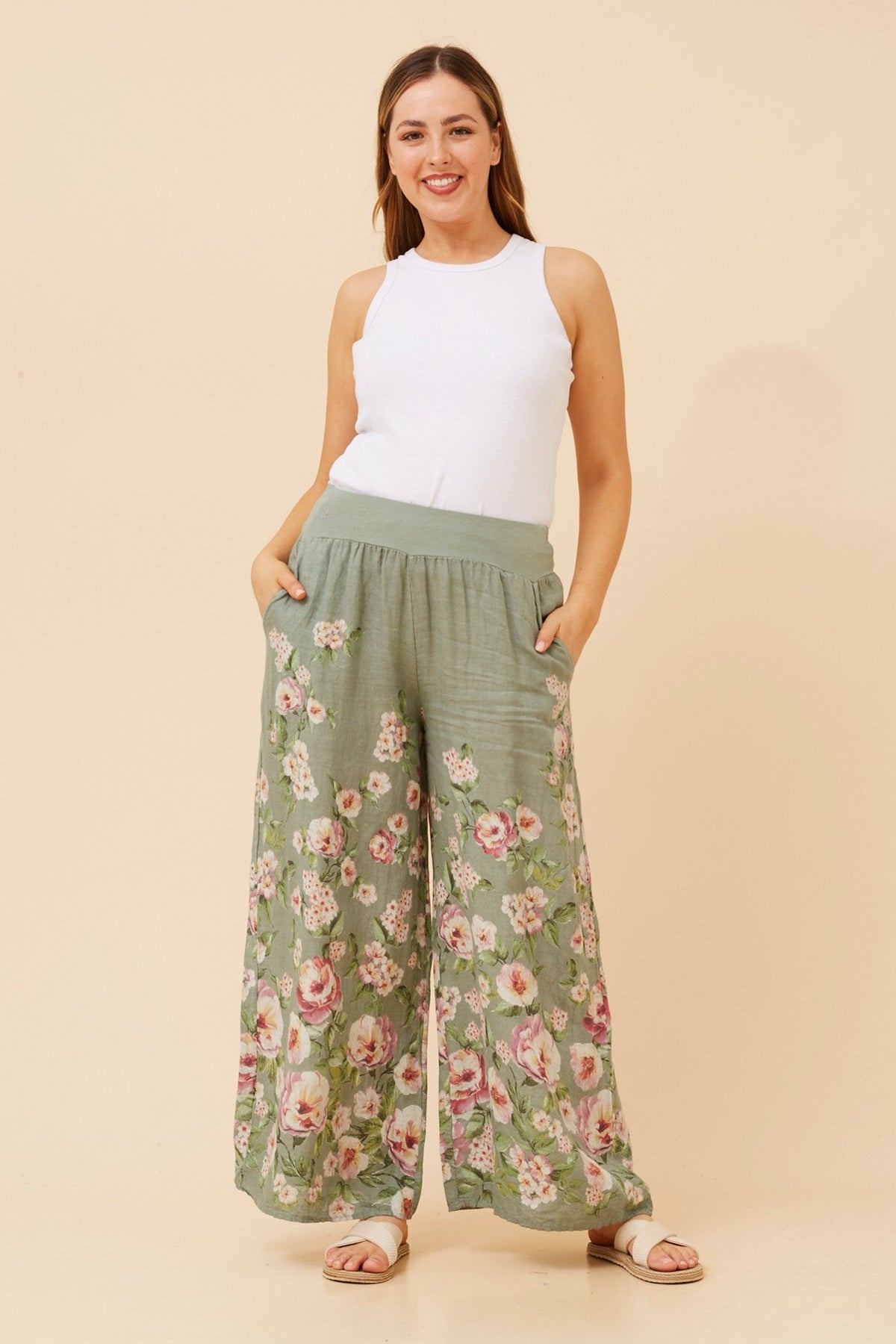 Image of a model wearing Pants. Product name - LEONORA FLORAL WIDE LEG LINEN PANTS in Sage colour by brand - BOTTEGA MODA