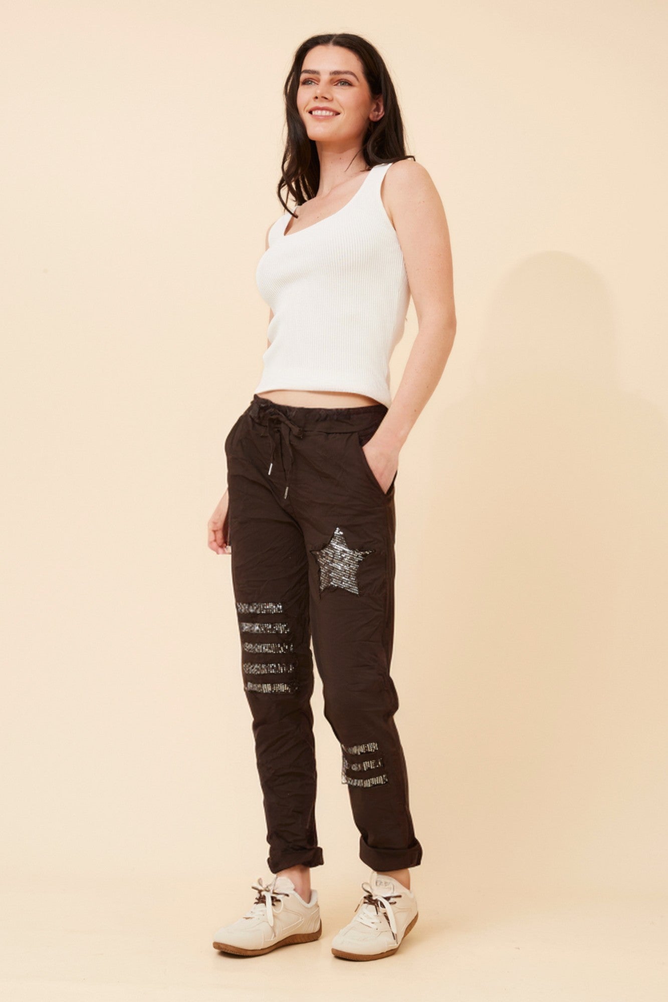 Image of a model wearing Pants. Product name - JANJA SEQUIN JOGGER PANTS in Navy colour by brand - BOTTEGA MODA