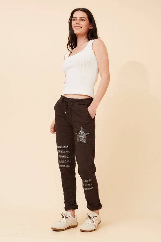 Image of a model wearing Pants. Product name - JANJA SEQUIN JOGGER PANTS in Navy colour by brand - BOTTEGA MODA