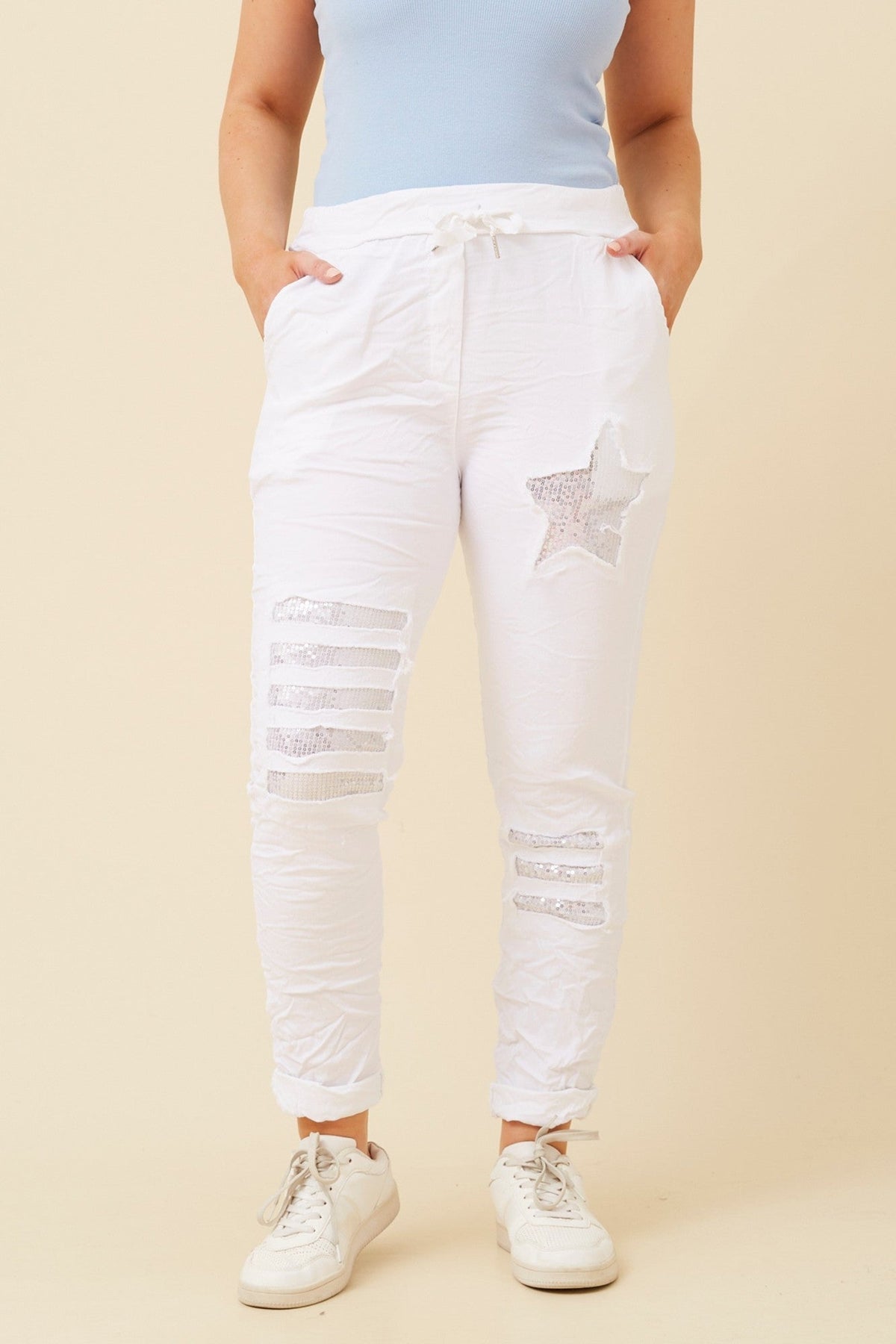 Image of a model wearing Pants. Product name - JANJA SEQUIN JOGGER PANTS in White colour by brand - BOTTEGA MODA