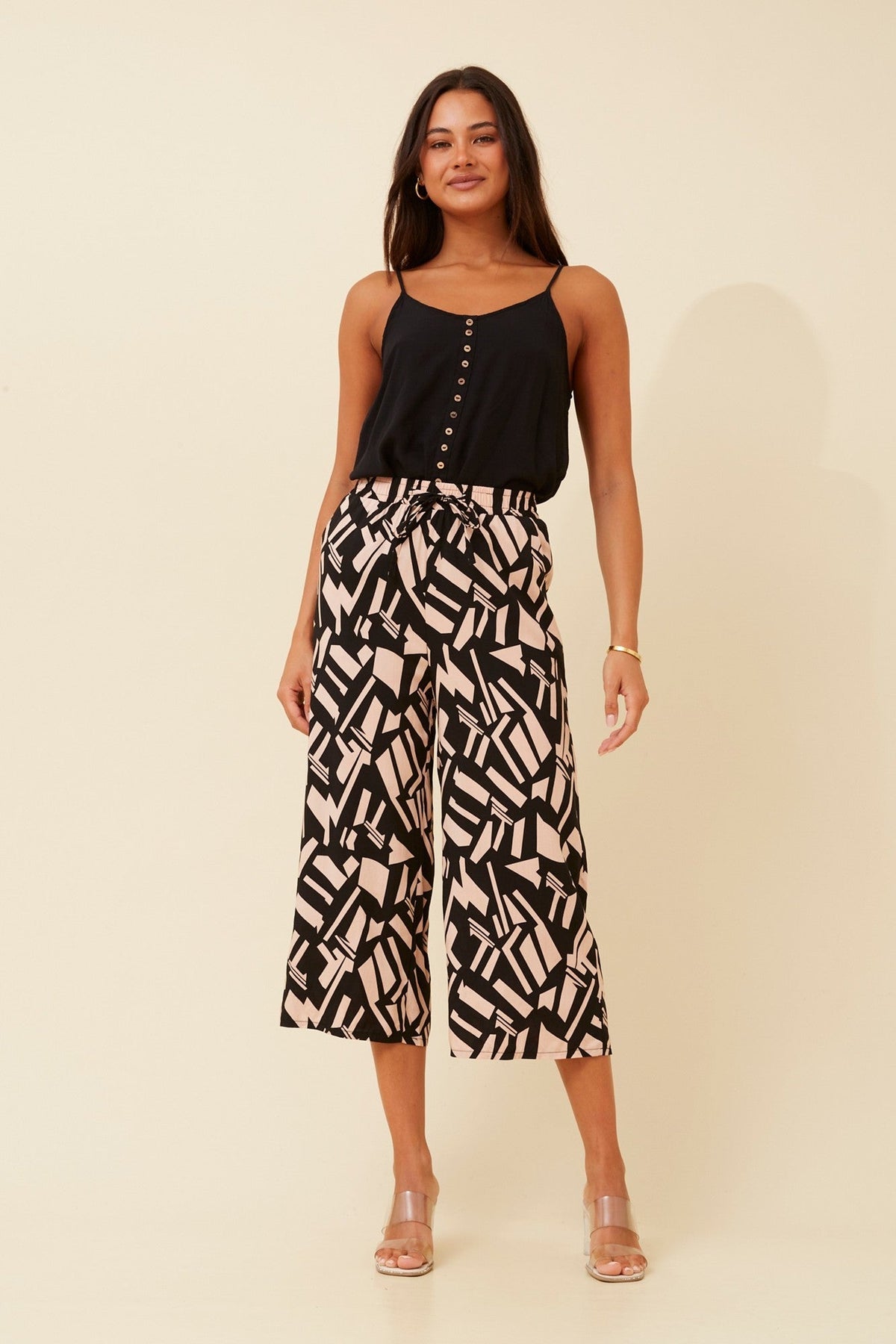 Image of a model wearing Pants. Product name - SUZE ABSTRACT PRINT CULOTTES in Black colour by brand - Caroline Morgan Australia