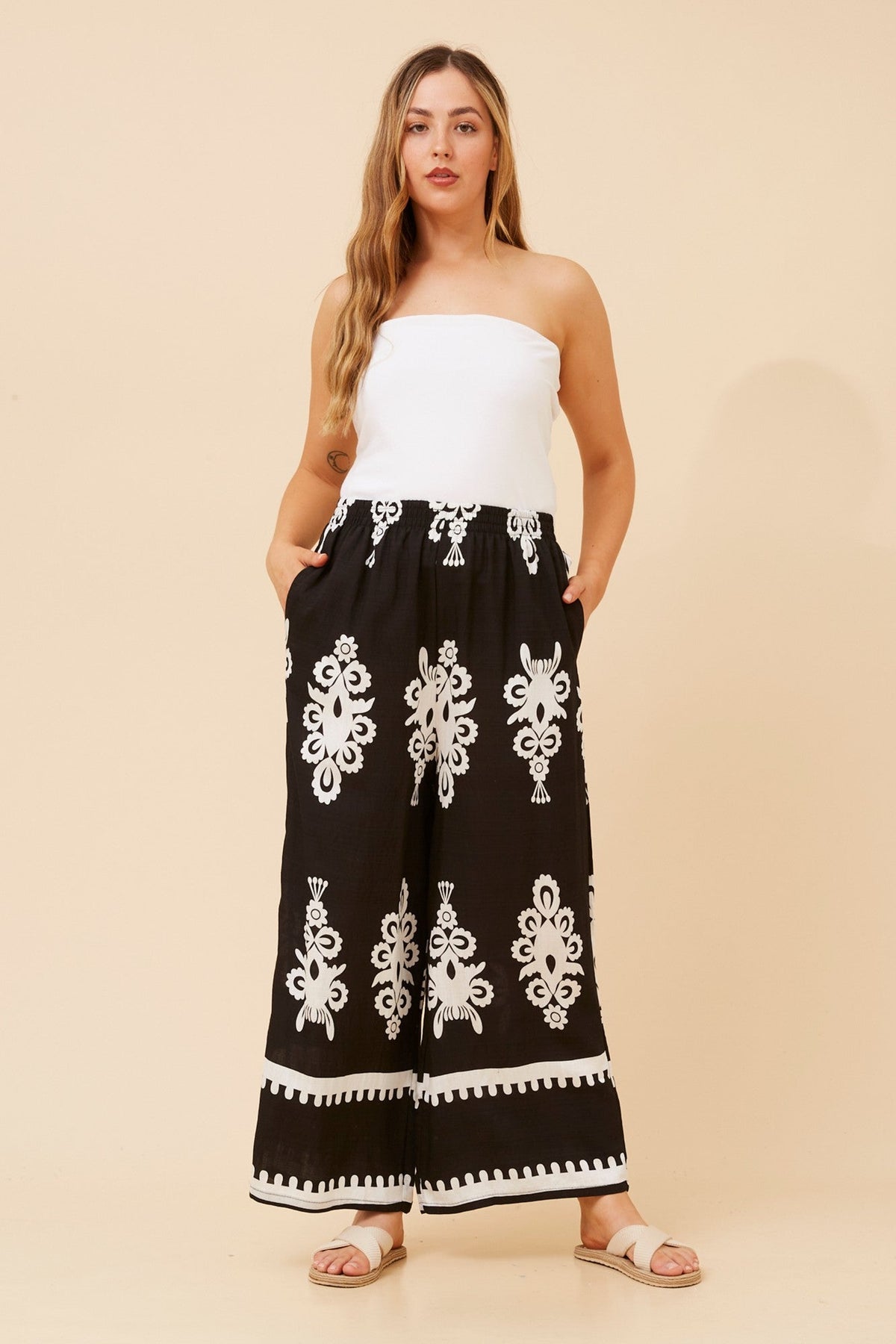 Image of a model wearing Pants. Product name - ANCA BORDER PRINT WIDE LEG PANTS in Navy colour by brand - Caroline Morgan Australia