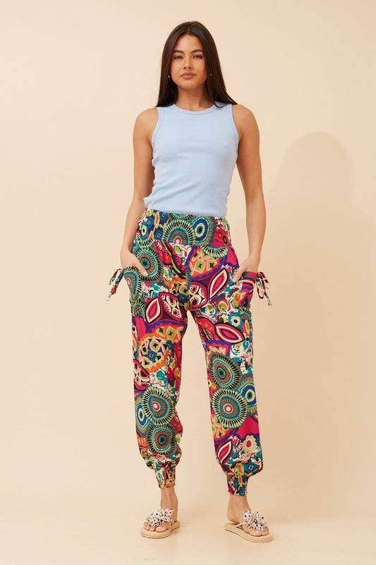 Image of a model wearing Pants. Product name - ABSTRACT PRINT HAREM PANTS in Multi Pink colour by brand - Caroline Morgan Australia