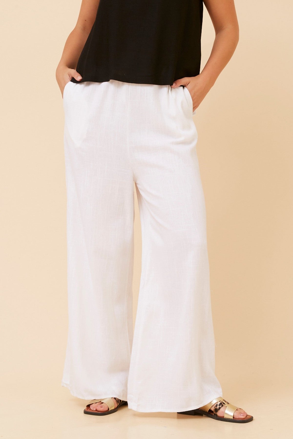 Image of a model wearing Pants. Product name - DONNY LINEN BLEND PANTS in White colour by brand - Caroline Morgan Australia