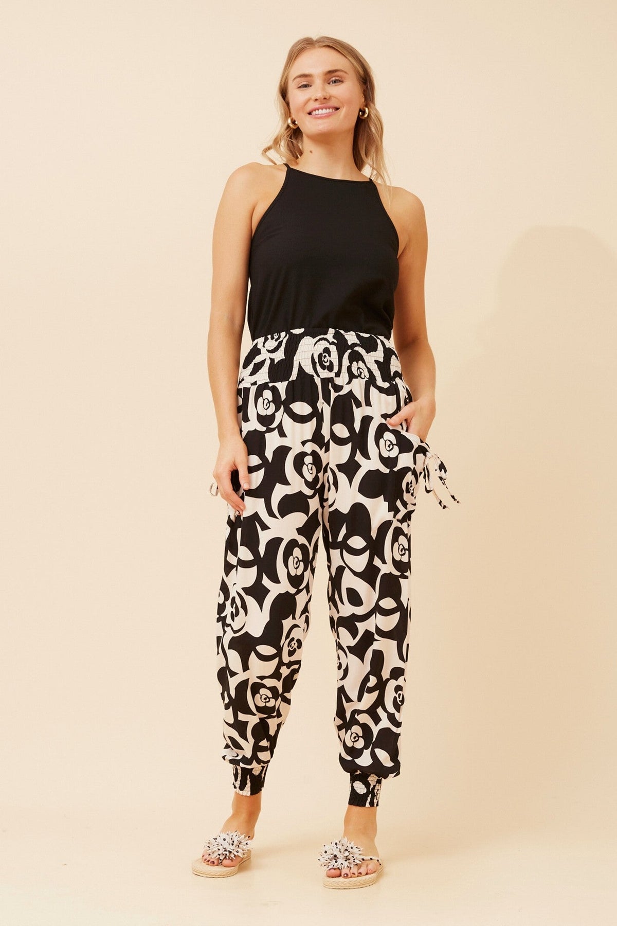Image of a model wearing Pants. Product name - ABSTRACT PRINT HAREM PANTS in Black colour by brand - Caroline Morgan Australia