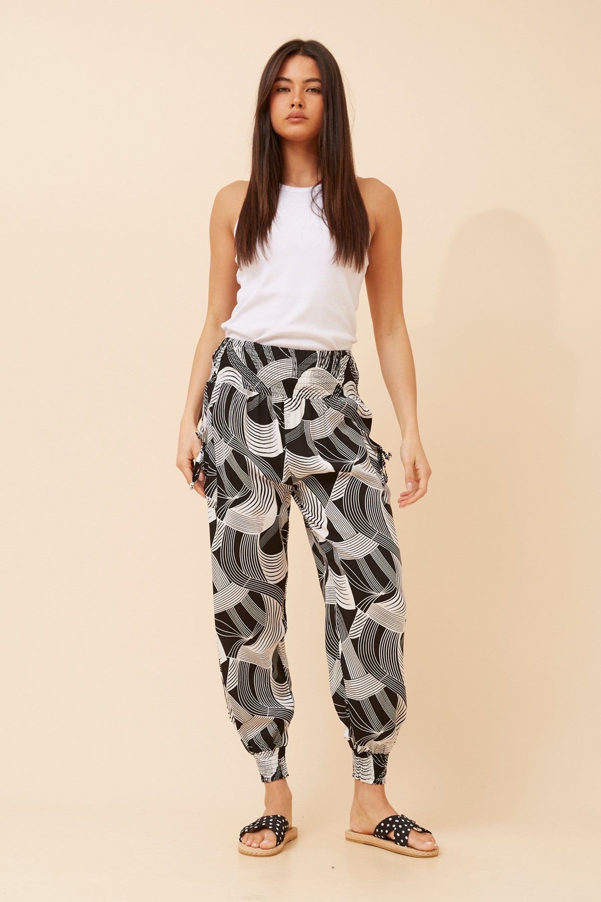 Image of a model wearing Pants. Product name - ABSTRACT PRINT HAREM PANTS in Black And White colour by brand - Caroline Morgan Australia