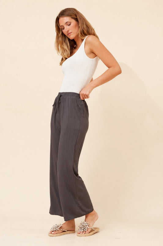Image of a model wearing Pants. Product name - SUZZEL SOLID WIDE LEG PANTS in Black colour by brand - Caroline Morgan Australia
