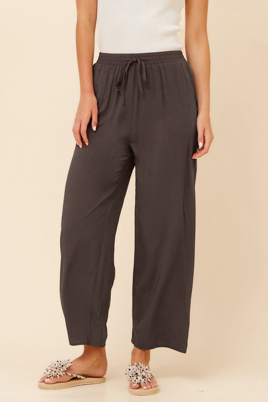 Image of a model wearing Pants. Product name - SUZZEL SOLID WIDE LEG PANTS in Bitter Chocolate colour by brand - Caroline Morgan Australia