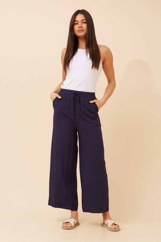 Image of a model wearing Pants. Product name - SUZZEL SOLID WIDE LEG PANTS in Black colour by brand - Caroline Morgan Australia