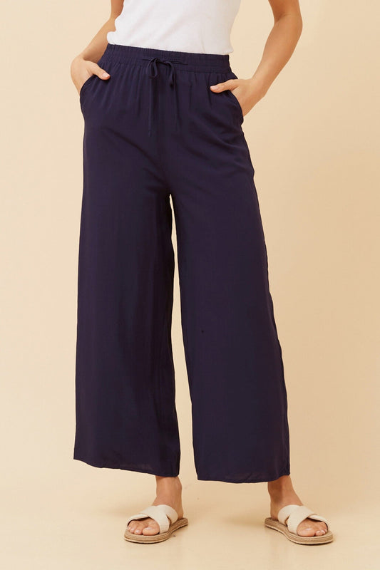 Image of a model wearing Pants. Product name - SUZZEL SOLID WIDE LEG PANTS in Navy colour by brand - Caroline Morgan Australia