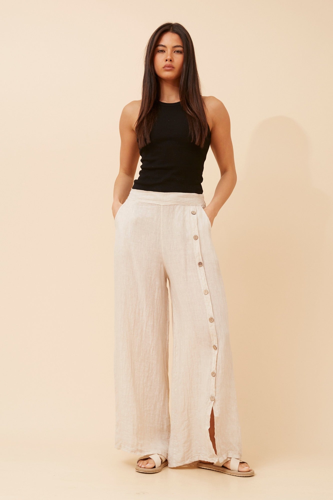 Image of a model wearing Pants. Product name - LUCA SOLID LINEN PANTS in Linen colour by brand - BOTTEGA MODA