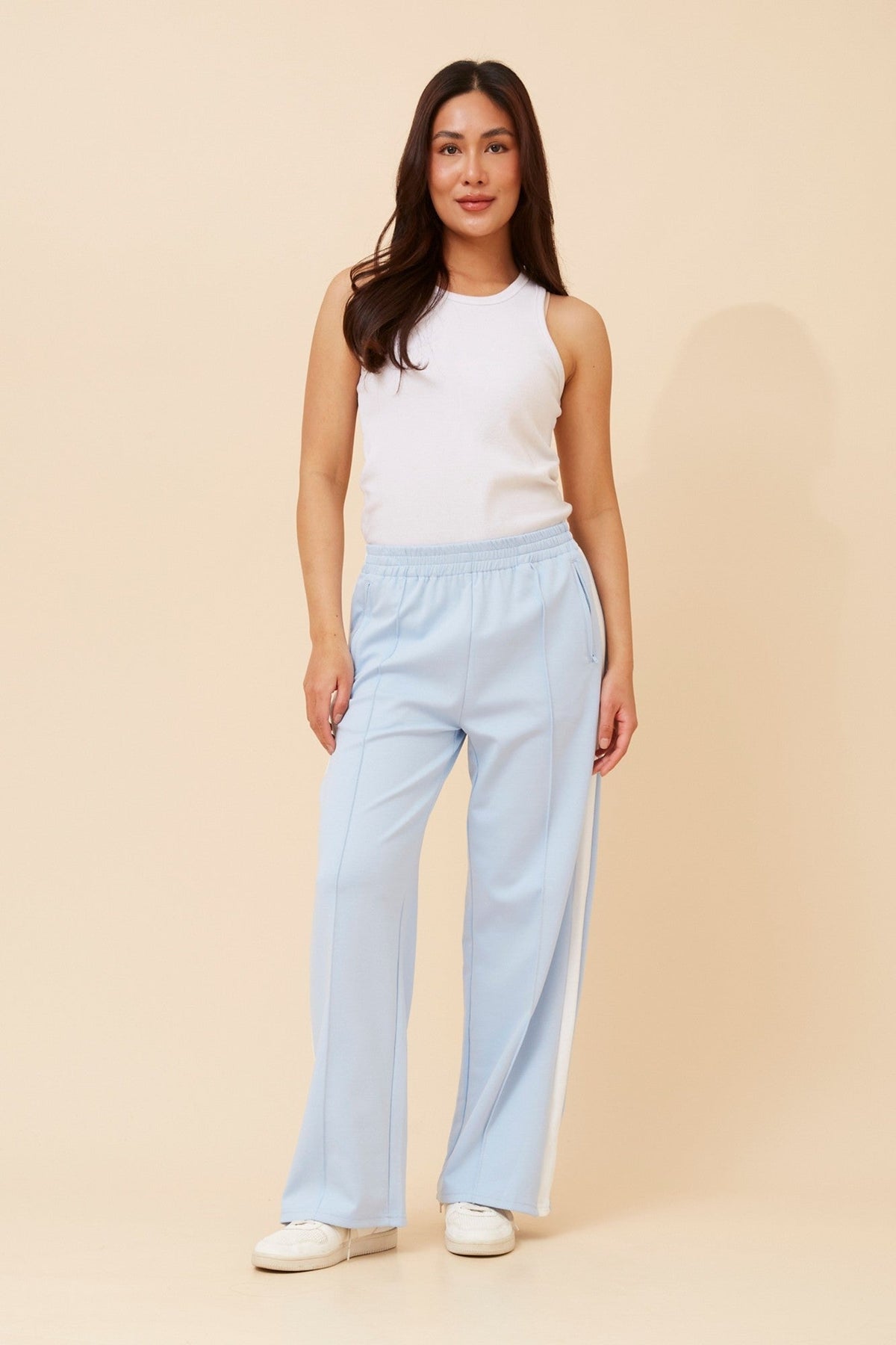 Image of a model wearing Pants. Product name - ORTENSA SIDE STRIPE PANTS in Beige colour by brand - Caroline Morgan Australia