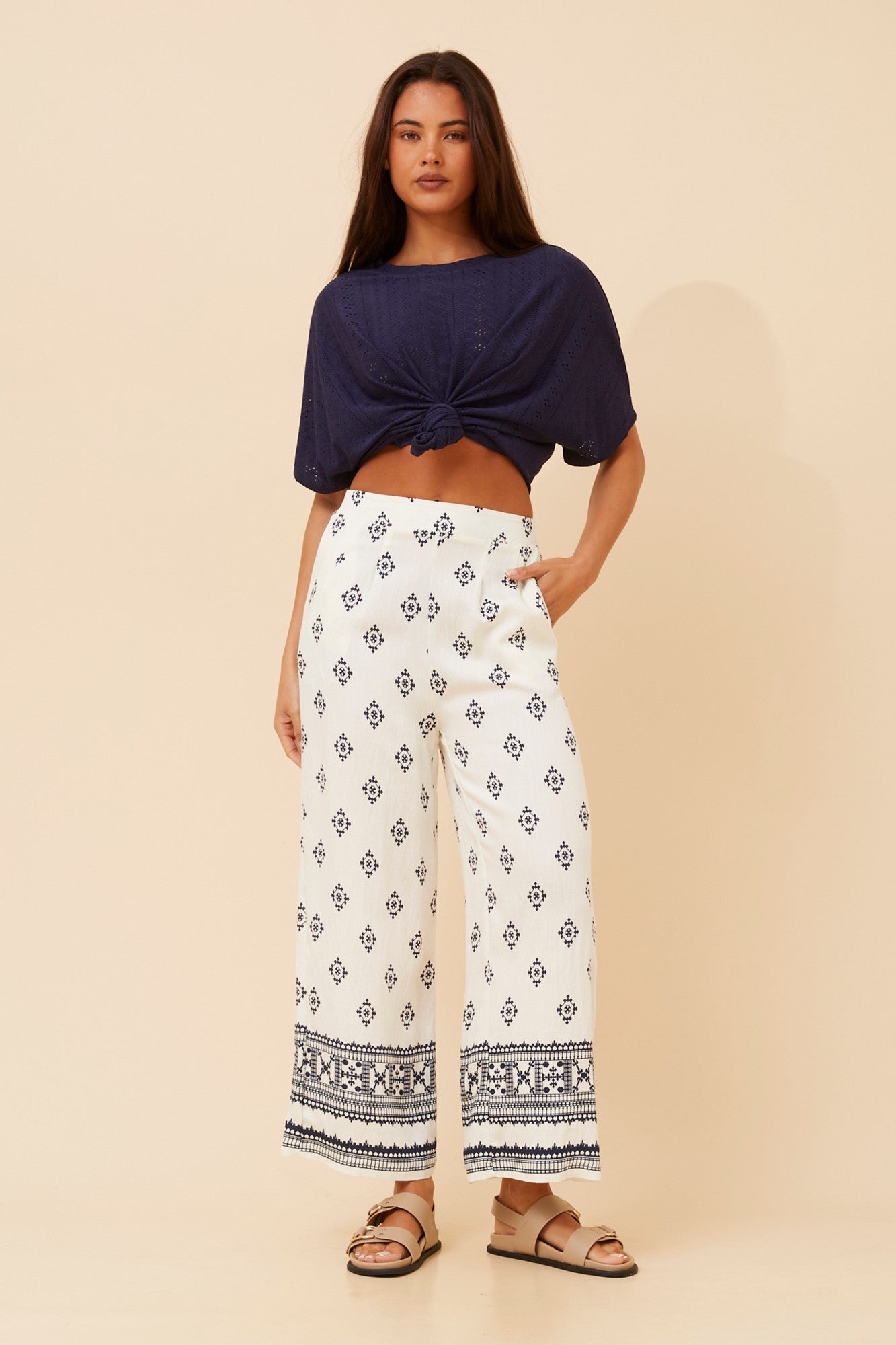 Image of a model wearing Pants. Product name - LOXANA BORDER PRINT WIDE LEG PANTS in Black/White colour by brand - Caroline Morgan Australia
