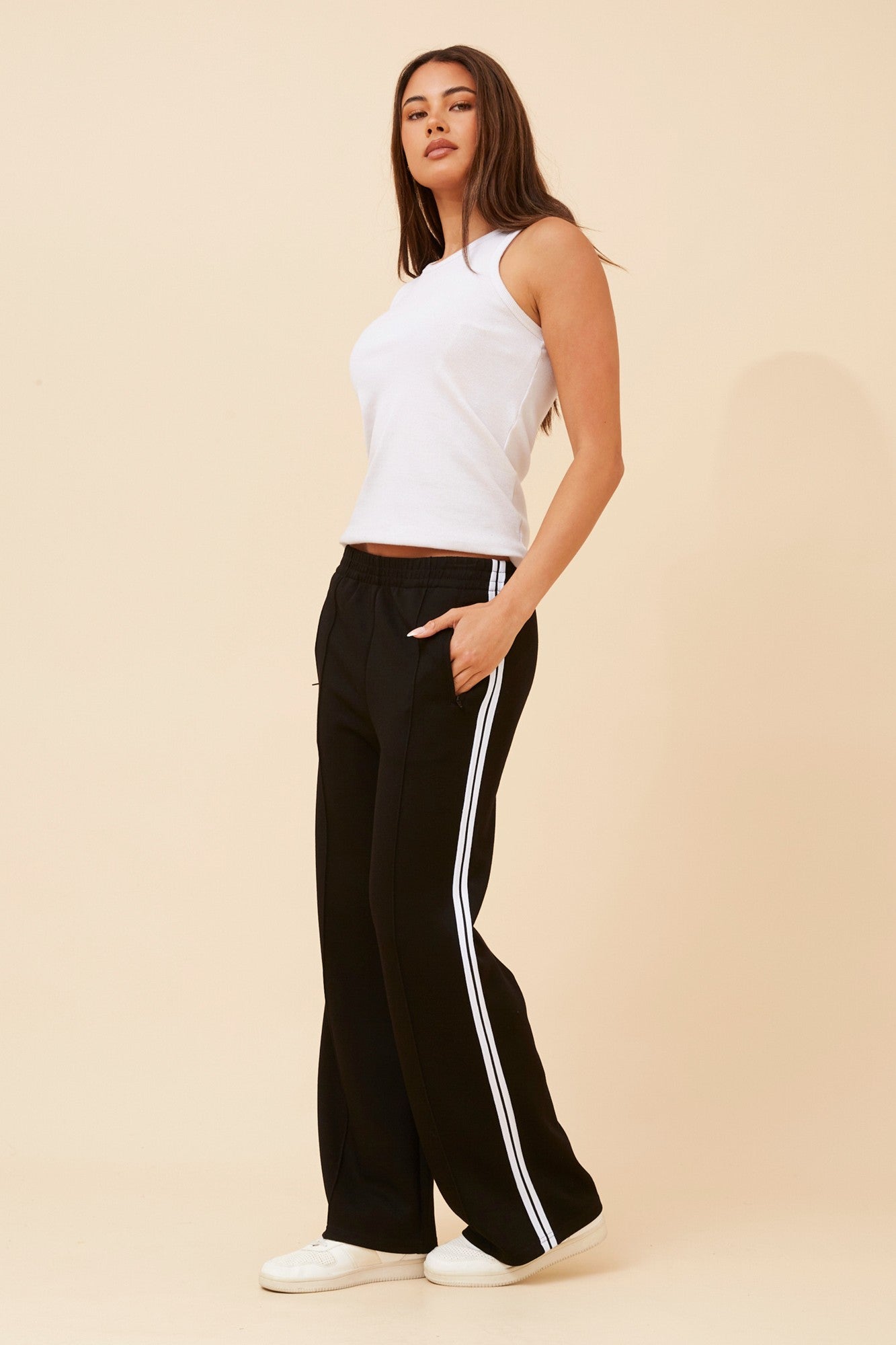 Image of a model wearing Pants. Product name - ORTENSA SIDE STRIPE PANTS in Black colour by brand - Caroline Morgan Australia