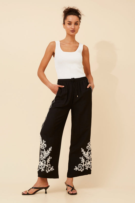 Image of a model wearing Pants. Product name - OREN EMBROIDERED WIDE LEG PANTS in Black colour by brand - Caroline Morgan Australia