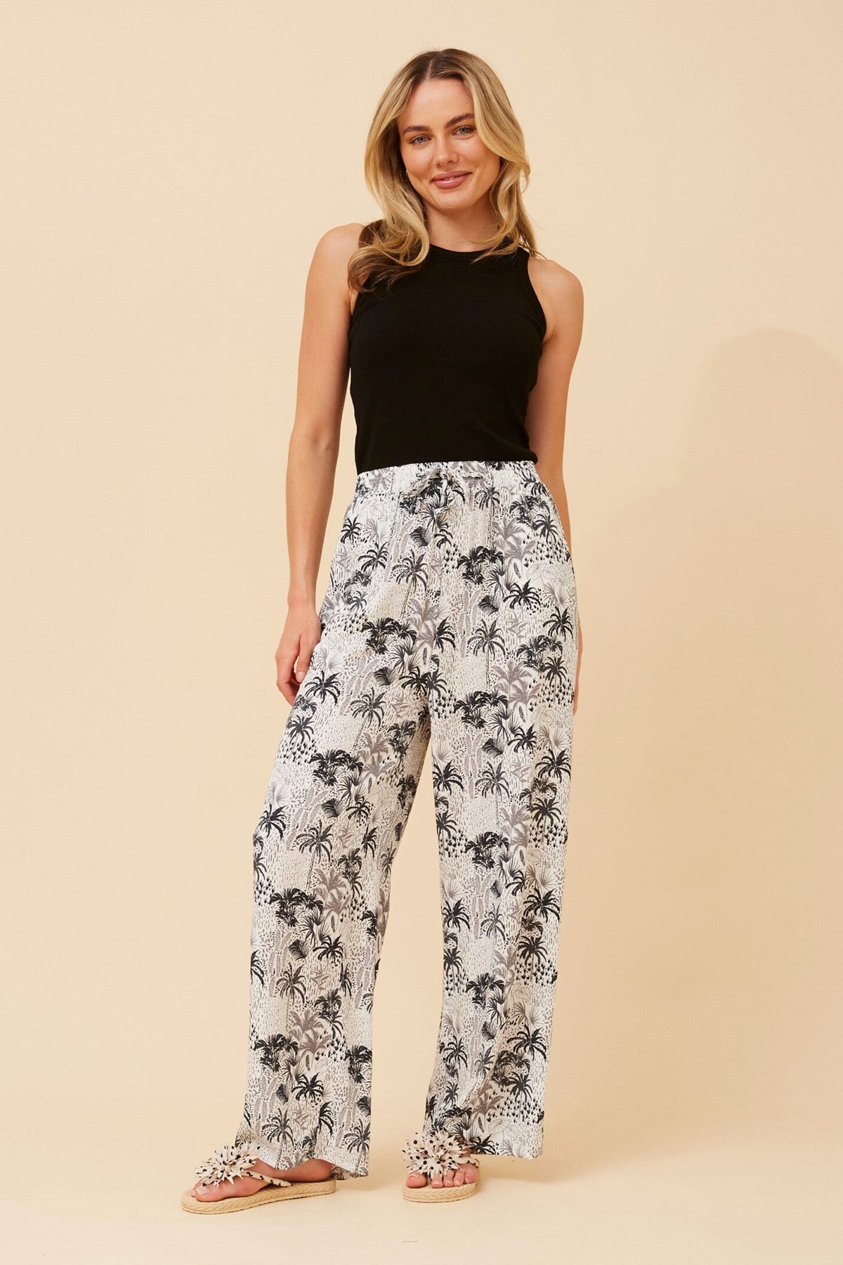 Image of a model wearing Pants. Product name - SUZZEL PALM TREE PRINT PANTS in White colour by brand - Caroline Morgan Australia