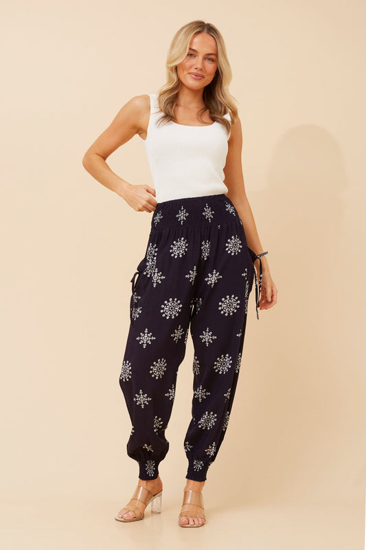 Image of a model wearing Pants. Product name - HAREM ABSTRACT PRINT PANTS in Navy colour by brand - Caroline Morgan Australia