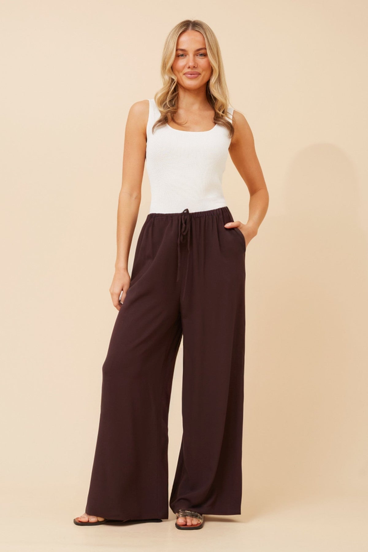 Image of a model wearing Pants. Product name - DONNY SOLID WIDE LEG PANTS in Chocolate colour by brand - Caroline Morgan Australia