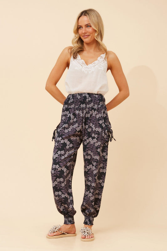 Image of a model wearing Pants. Product name - HAREM FLORAL PANTS in Navy colour by brand - Caroline Morgan Australia