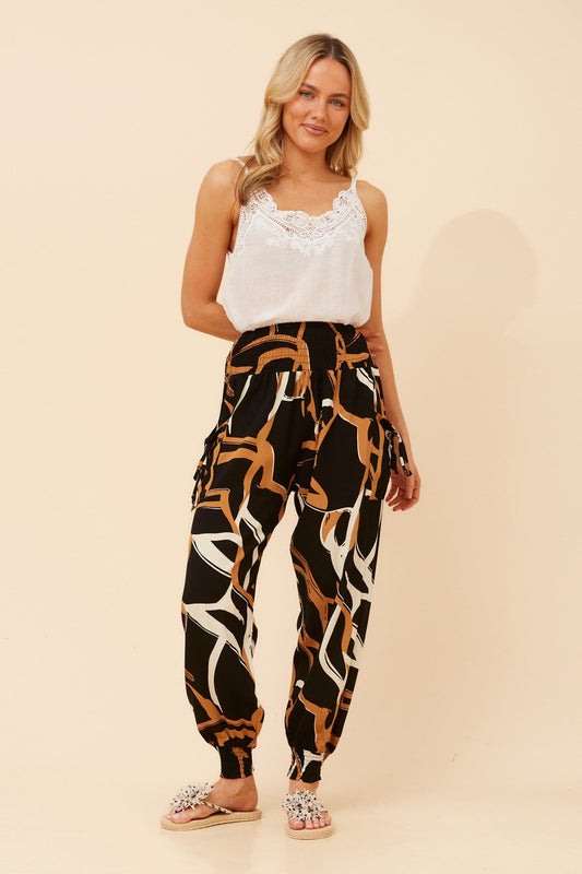 Image of a model wearing Pants. Product name - HAREM ABSTRACT PRINT PANTS in Toffee colour by brand - Caroline Morgan Australia