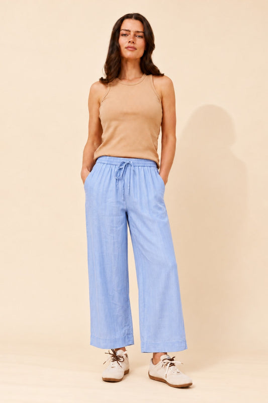 Image of a model wearing Pants. Product name - ALLORAH SOLID WIDE LEG PANTS in Light Denim colour by brand - MYSTIC MONSOON