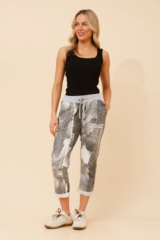 Image of a model wearing Pants. Product name - GINNA ABSTRACT PRINT JOGGER PANTS in Black colour by brand - BOTTEGA MODA