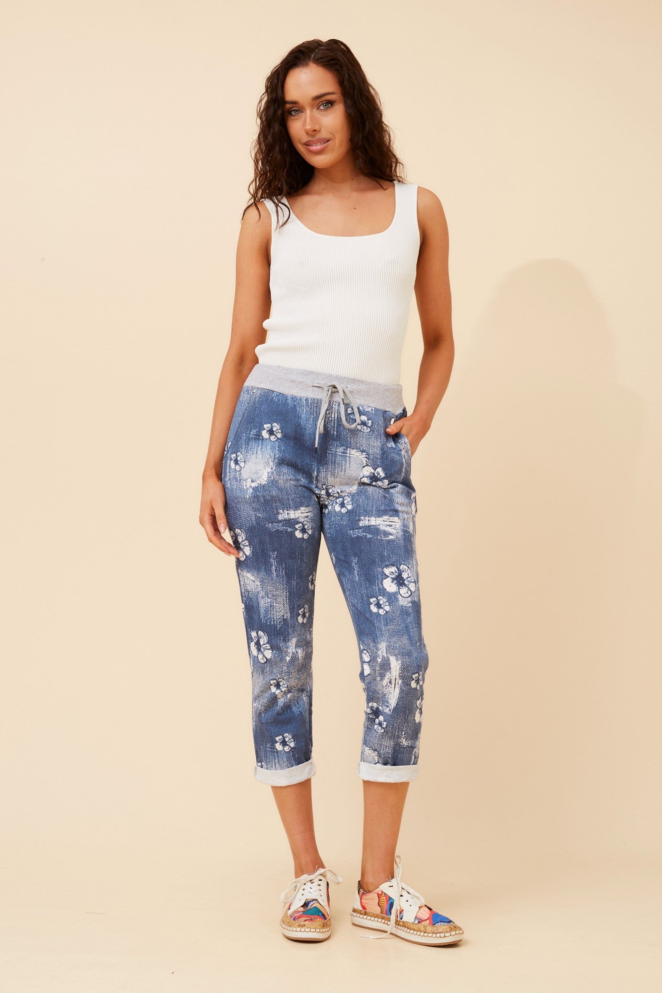 Image of a model wearing Pants. Product name - GINNA FLORAL JOGGER PANTS in Blue colour by brand - BOTTEGA MODA