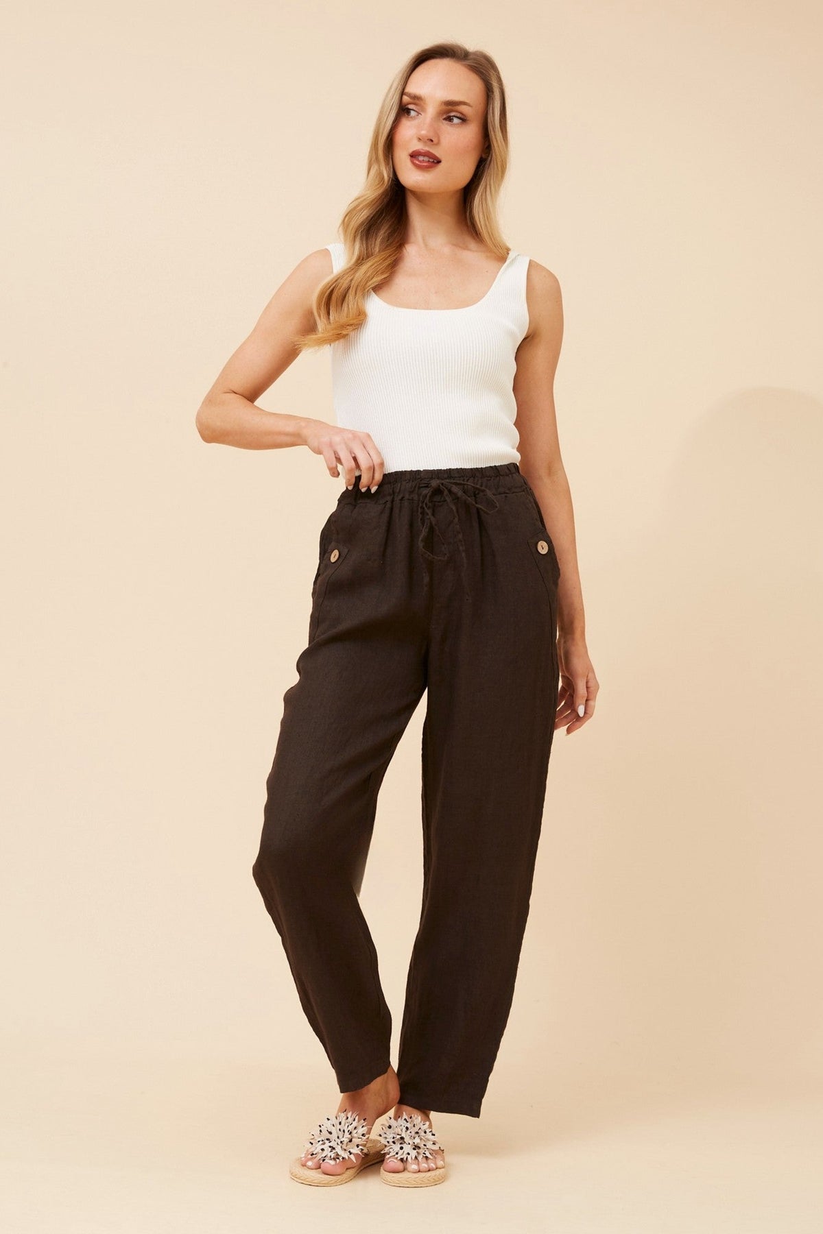 Image of a model wearing Pants. Product name - AMIR SOLID LINEN PANTS in Chocolate colour by brand - BOTTEGA MODA