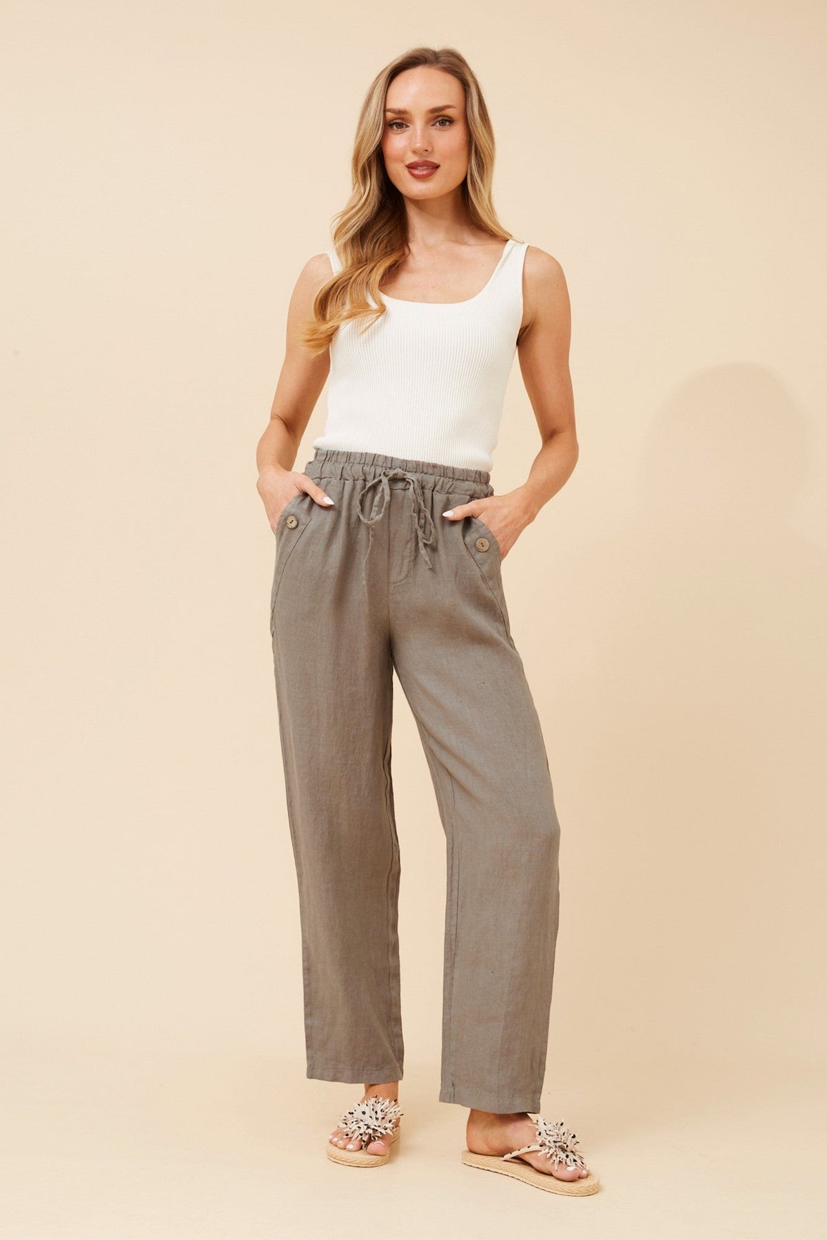 Image of a model wearing Pants. Product name - AMIR SOLID LINEN PANTS in Fango colour by brand - BOTTEGA MODA