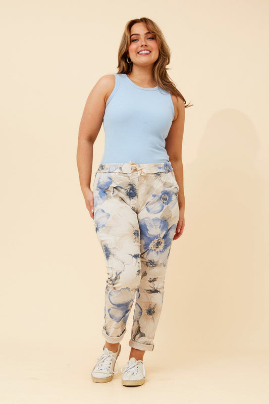 Image of a model wearing Pants. Product name - JANJA FLORAL JOGGER PANTS in Multi White colour by brand - BOTTEGA MODA