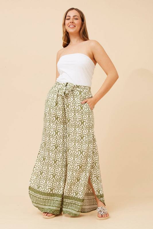 Image of a model wearing Pants. Product name - SISKA BORDER PRINT WIDE LEG PANTS in Sage colour by brand - Caroline Morgan Australia
