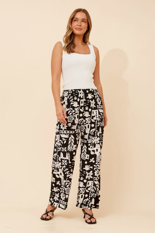 Image of a model wearing Pants. Product name - YULENKA WANDERLUST PRINT PANTS in Black/Cream colour by brand - Caroline Morgan Australia