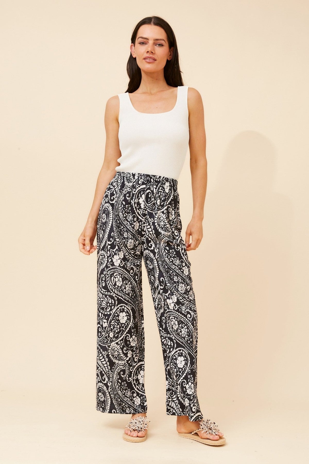Image of a model wearing Pants. Product name - YULENKA PAISLEY PRINT PANTS in Black colour by brand - Caroline Morgan Australia