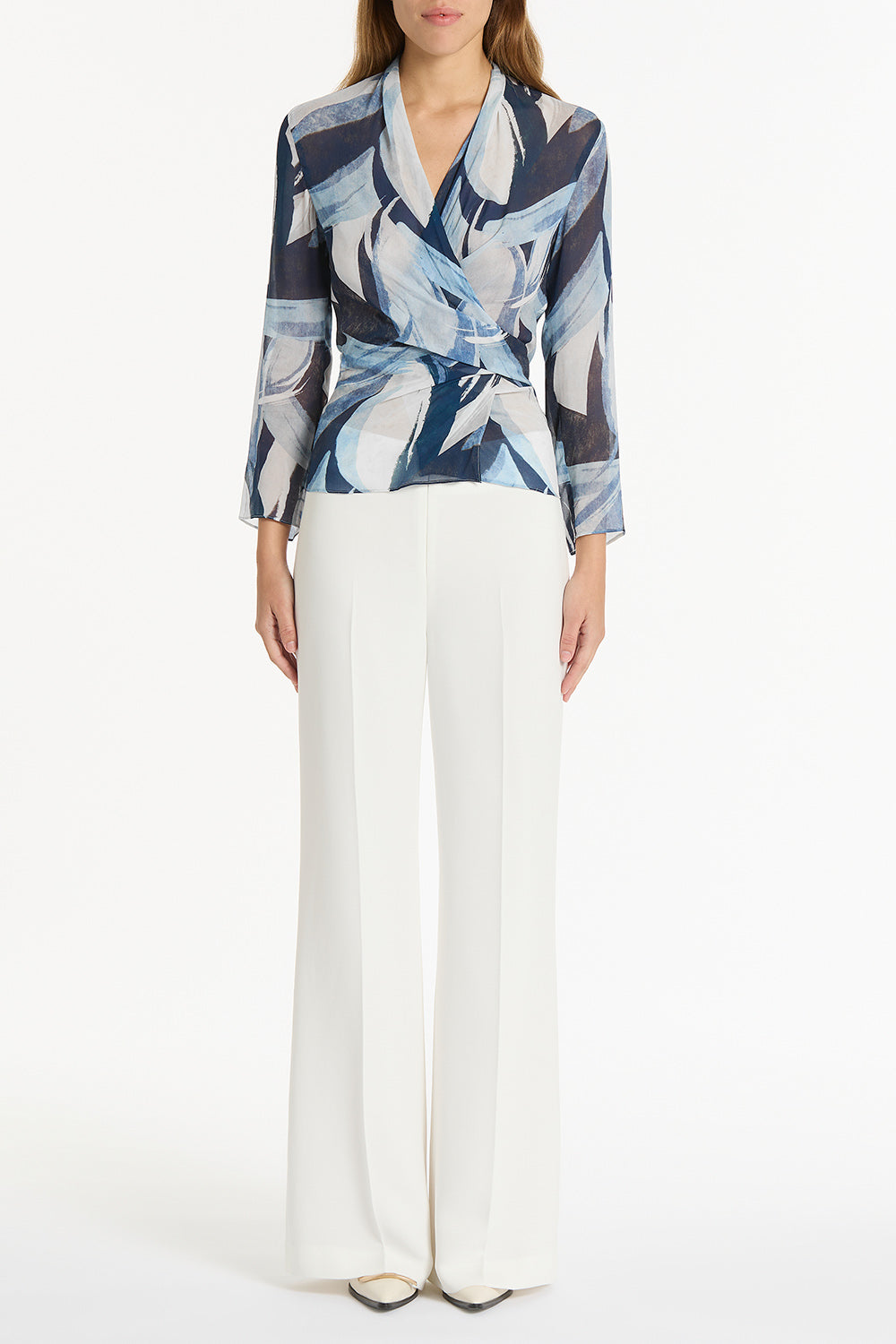 Image of a model wearing Tops. Product name - Painted Floral Georgette Wrap Top in Blue colour by brand - Carla Zampatti